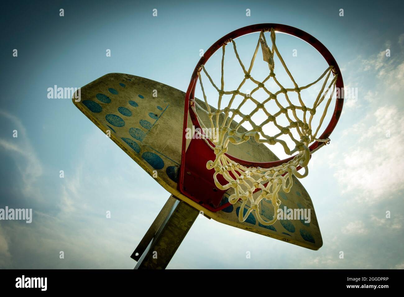Basketballkorb vor blauem Himmel auf einem Platz im Freien, um bei Tageslicht sportliche Momente festzuhalten Stockfoto