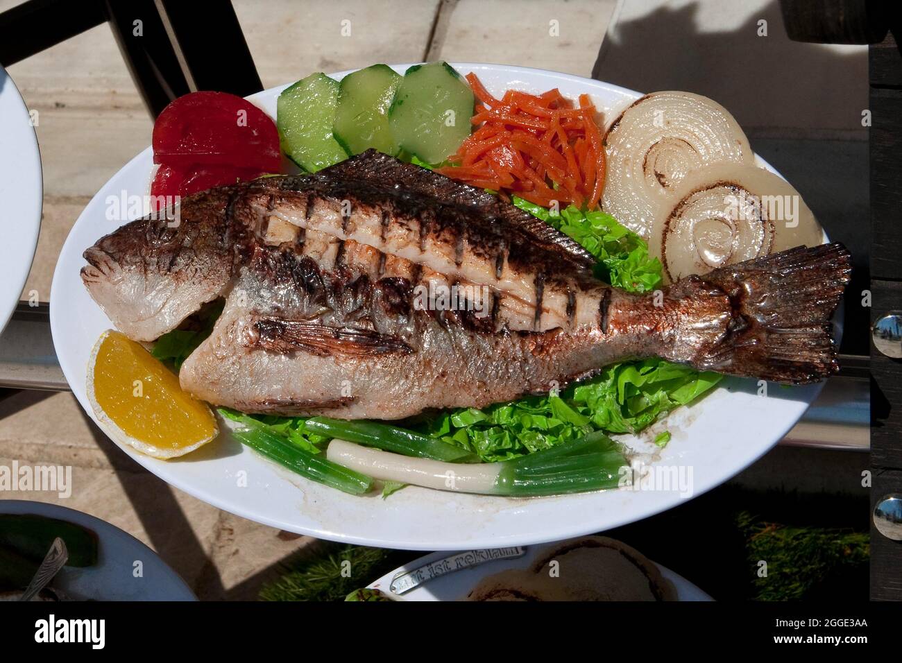 Mediterranes Fischgericht gegrillte Goldbrasse (Sparidae) im Restaurant an der Hafenpromenade, Bodrum, Türkei Stockfoto