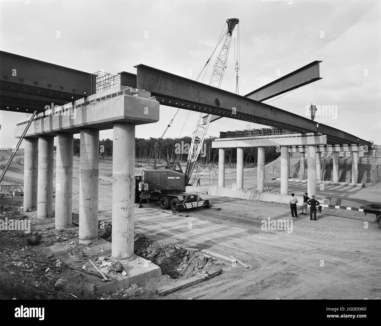 Ein Blick auf den Bau der Midland Link Autobahn, zwischen Junction 13 und Junction 11 der M6, zeigt Stahlträger, die auf einer der Brücken abgesenkt wurden. Dieses Foto wurde im Oktober 1964 in Laings monatlichem Newsletter „Team Spirit“ veröffentlicht. Stockfoto