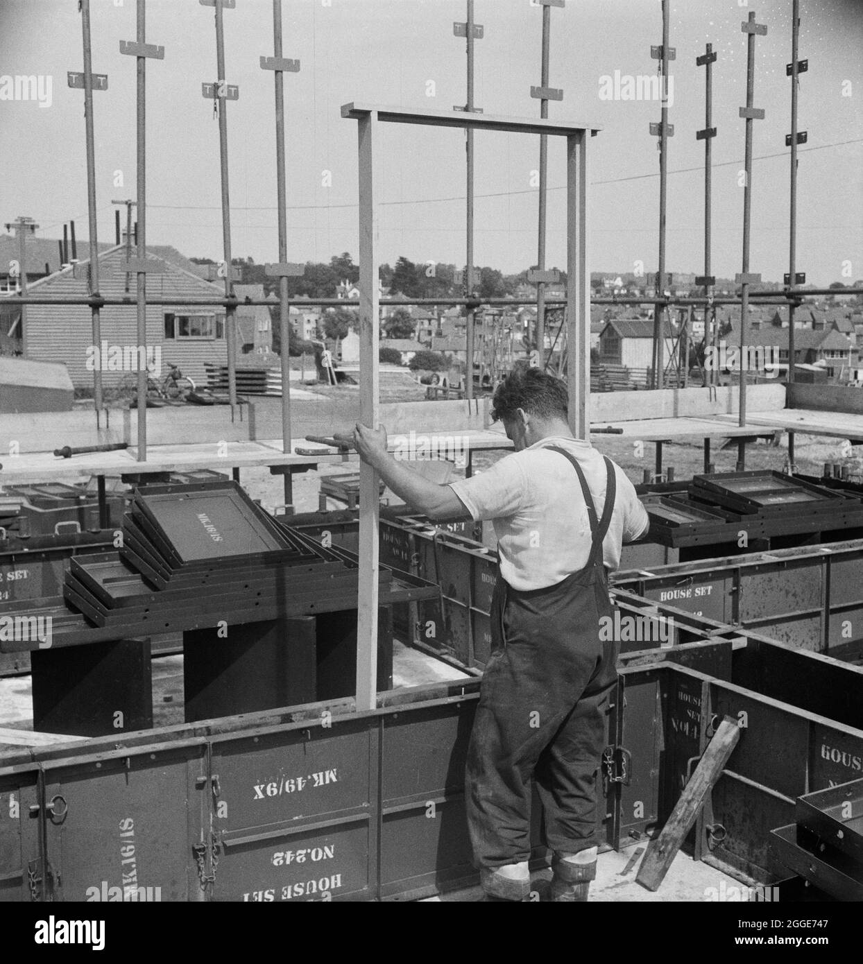 Ein Mann, der beim Bau einer Wohnsiedlung in Hastings den Rahmen für eine Tür in die Schalung eines Easiform-Hauses legte. „Easiform“ war eine Methode der in situ vorgegossenen Betonkonstruktion, die John Laing und Son Ltd ab 1919 entwickelten. Stockfoto