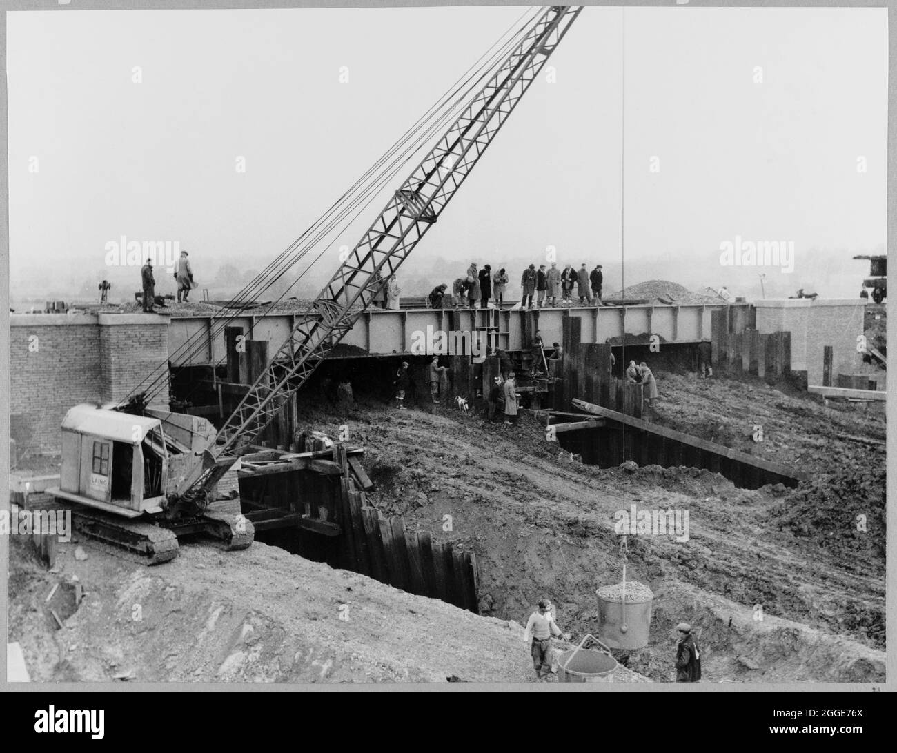 Eine Ansicht zeigt das Deck der Struktur 112 in Position, eine Eisenbahnbrücke über die London zur Yorkshire Motorway (die M1), als Ruston Bucyrus Maschinenhebemaschine Ballast im Vordergrund. Das Deck der Struktur 112 wurde neben der Stelle der Brücke gebaut und dann in Position gerollt. Die Struktur 112 liegt an der M45, einer Straße, die an der Anschlussstelle 17 von der M1 abzweigt und nach Thurlaston bei Dunchurch führt. Diese Erweiterung wurde als Teil der 'London to Yorkshire Motorway' gebaut und gleichzeitig eröffnet. Stockfoto