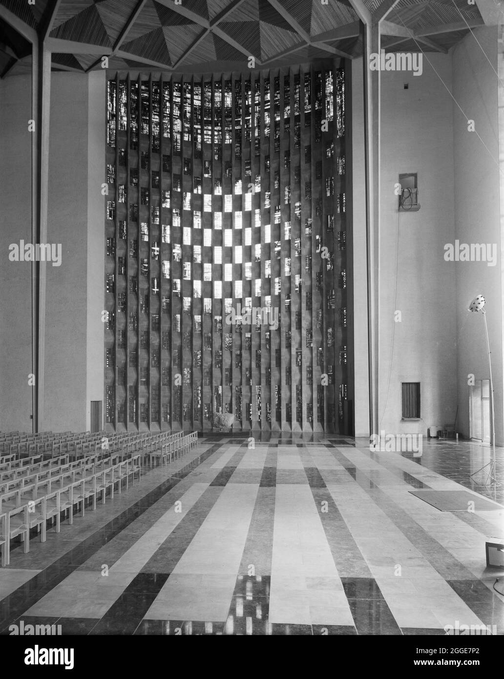 Blick über das Innere der Kathedrale von Coventry auf das Tauffenster. Das Foto ist Teil einer Serie, die von John Laing &amp; Son aufgenommen wurde, um den fertigen Vertrag der Coventry Cathedral zu zeigen, der von der Firma zwischen Mitte der 1950er und 1962 gebaut wurde. Das Baptisterium-Fenster wurde von John Piper entworfen und von Patrick Reyntiens angefertigt. Die 198 Paneele wurden von John Piper in einem Zeitraum von fast zwei Jahren zwischen 1958 und 1960 entworfen. Die Glasmalerei wurde über drei Jahre hergestellt, die Installation begann im Mai 1961. Stockfoto