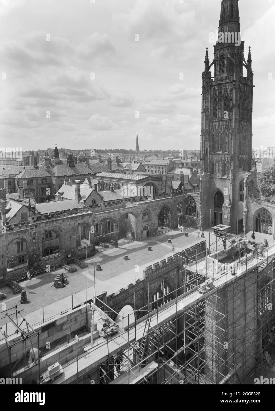 Ein Blick nach Südwesten über die Ruinen der Kathedrale St. Michael vom Dach der neuen Kathedrale von Coventry aus, der im Vordergrund einen Teil der Baustelle neben der alten Kathedrale zeigt. Nach dem Bombenangriff auf die Kathedrale von Coventry im November 1940 wurde 1950 ein Wettbewerb gestartet, um einen Entwurf für eine neue Kathedrale zu finden. Das Siegerdesign stammt von Sir Basil Spence (1907-1976) aus einem von über 200 eingereichten Designs. Die Bauarbeiten fanden zwischen Mitte der 1950er und 1962 statt. Am 23. März 1956 legte Königin Elisabeth II. Den Grundstein. Stockfoto