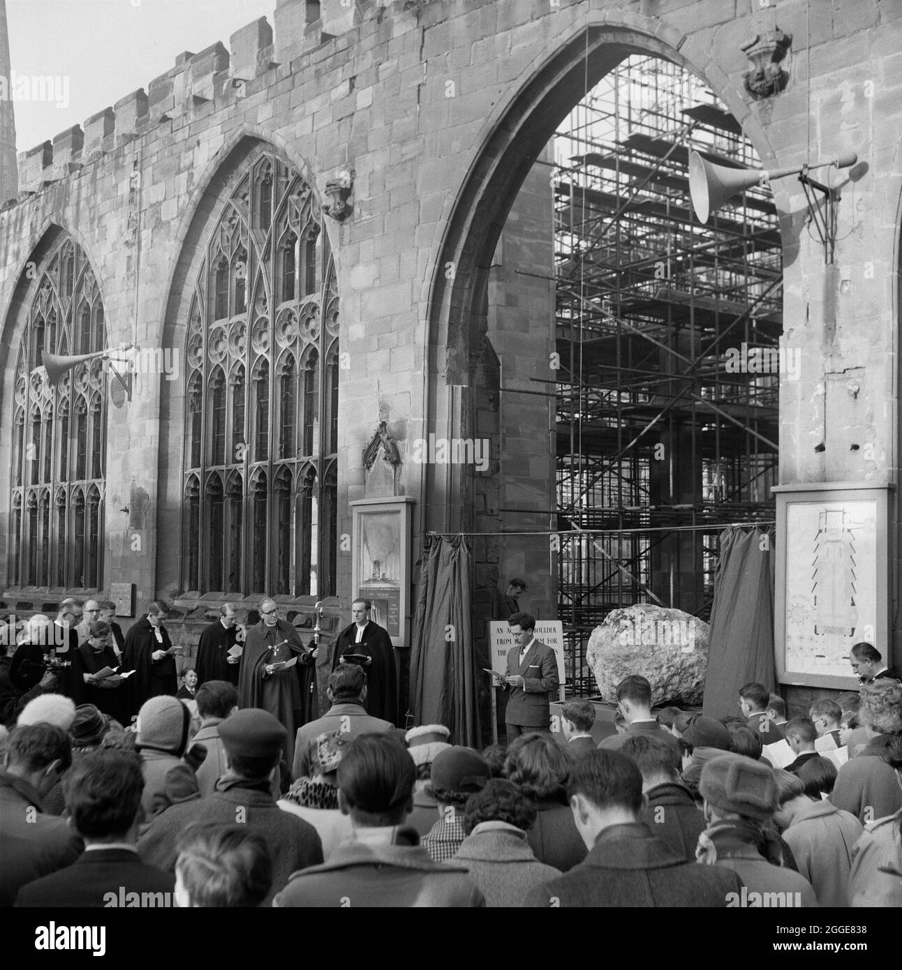 Eine Menge Leute versammelten sich vor der Kathedrale von Coventry zur Enthüllung des Felsens aus Bethlehem. Der Felsbrocken, der von einem Hügel in Bethlehem gebracht wurde, wurde zur Kathedrale von Coventry transportiert, um dort als neues Taufbecken verwendet zu werden. Mit einem Gewicht von drei Tonnen wurde er in der SS Norman Prince nach Manchester Docks und dann nach Coventry transportiert. Die Enthüllungszeremonie fand am 22. Dezember 1960 statt und der Felsbrocken wurde vom 7-jährigen Henry Sumner, Sohn des Zimmermanns in der Coventry Cathedral, enthüllt. Der Felsbrocken wurde später an seine aktuelle Position vor dem Tauffenster gebracht. Stockfoto