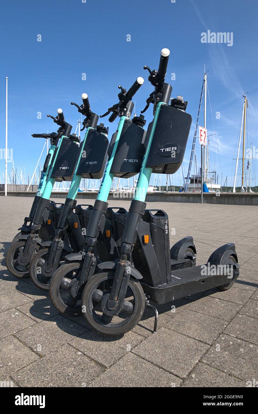 Kiel, Deutschland. August 2021. Kiel, geparkt E-Scooter von der Provider TIER Mobility GmbH auf der Kiellinie. Nach dem Gebrauch können die E-Scooter in Parkzonen geparkt werden, die der Kunde über die App finden kann. Oft halten die Roller aber auch an anderen Orten an oder liegen. Die Mitarbeiter des Vermieters holen dann die E-Scooter ab und laden die Batterien wieder auf. Nur für redaktionelle Zwecke Nur für redaktionelle Zwecke Kredit: dpa/Alamy Live Nachrichten Stockfoto