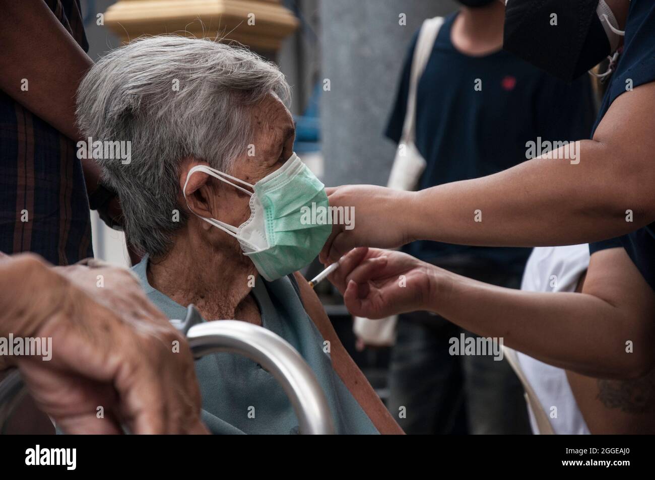 Ein Gesundheitsmitarbeiter verabreicht einem älteren Menschen an der Raj Pracha High School in Samut Prakarn den Pfizer-BioNTech Covid-19-Impfstoff. Das Bang Chak Hospital in der Provinz Samut Prakarn wurde für die Walk-in-Impfung der Einwohner von Samut Prakarn eröffnet, um ihre erste Dosis des Pfizer-Impfstoffs in Raj Pracha High zu erhalten. Einwohner der Provinz Samut Prakarn mit hohem Risiko, die sich für den Impfstoff qualifiziert haben, sind über 60 Jahre alt, schwanger oder haben bereits bestehende Erkrankungen, erhielten ihre erste Dosis des Pfizer-BioNTech COVID-19-Impfstoffs, die vom 30. August bis 1. September 2021 um 8 Uhr und bis 14 Uhr begann (Foto: Peerapo Stockfoto