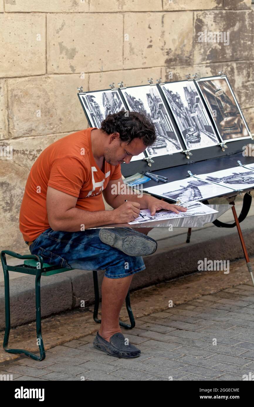 Mann, Kubaner zeichnet und verkauft seine Arbeit an einem Stand auf der Straße, in der Altstadt, in der Hauptstadt Havanna, in der Provinz Havanna, in den Großantillen, Karibik, Kuba Stockfoto