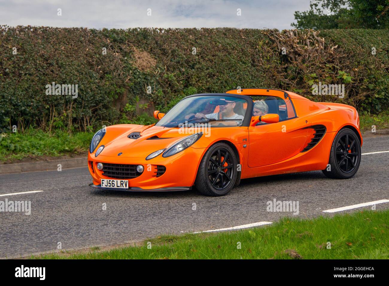 2006 oranger Lotus Elise 156V Touring 1796 ccm Benziner-Sportwagen auf dem Weg zur Capesthorne Hall Classic August Car Show, Ceshire, Großbritannien Stockfoto