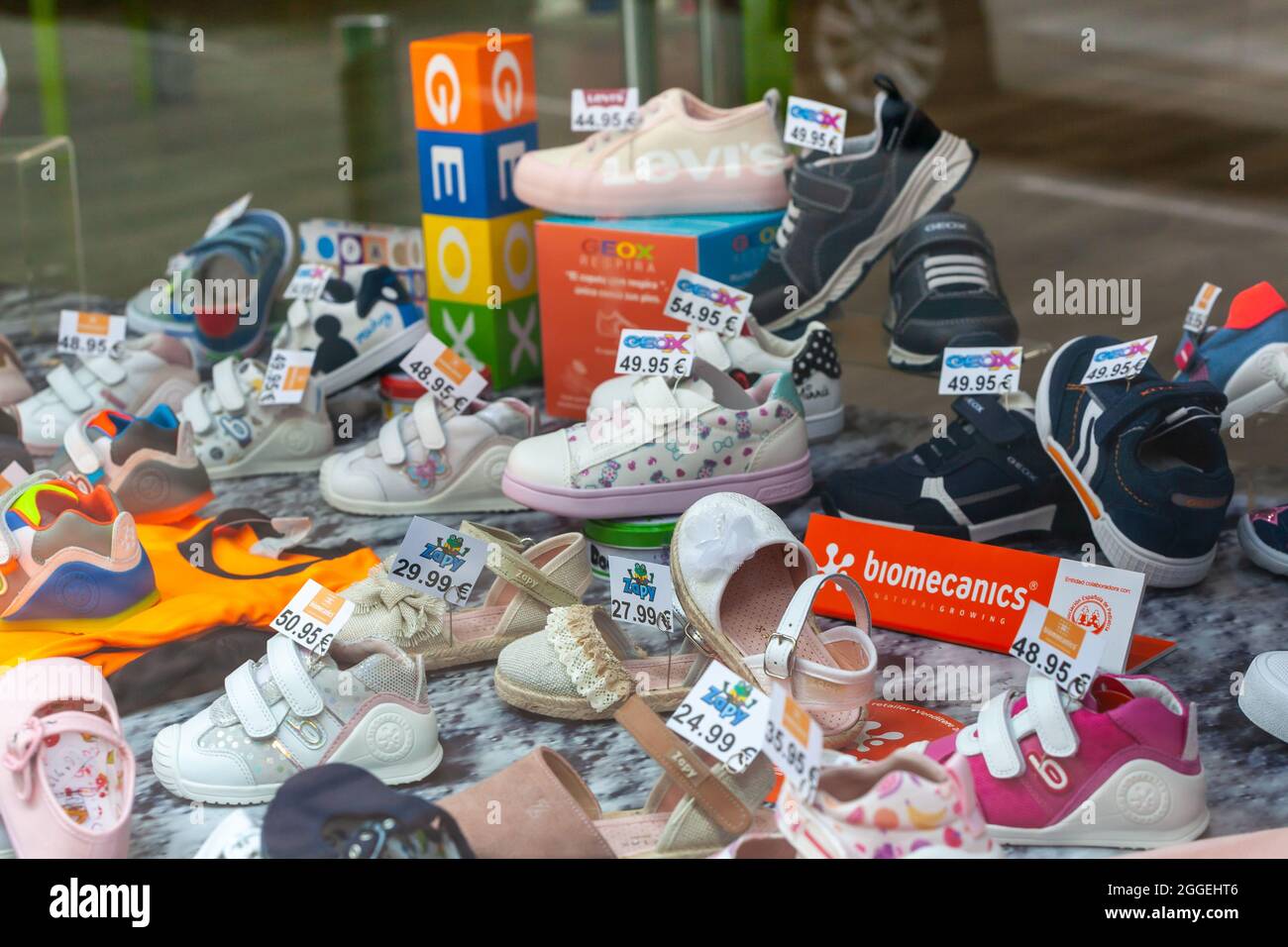 PLASENCIA, SPANIEN - 14. Apr 2021: Ein Straßenstand mit bekannten Markenschuhen und -Schuhen für Kleinkinder und Kleinkinder mit Preisschildern Stockfoto