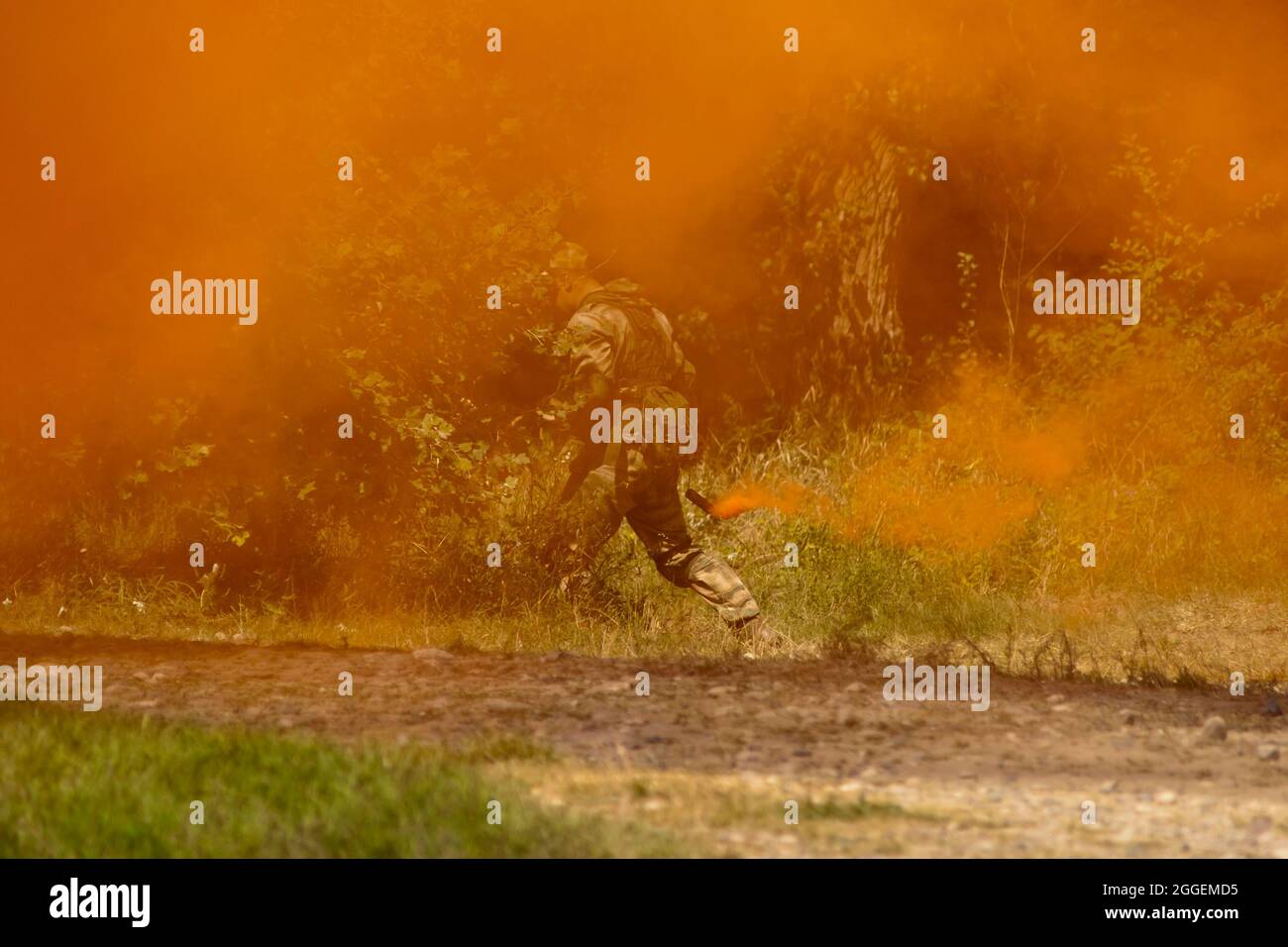 Fragment einer militärischen Demonstrationsvorstellung. Ein Soldat auf einem Rauchschirm trägt Signalbomben Stockfoto