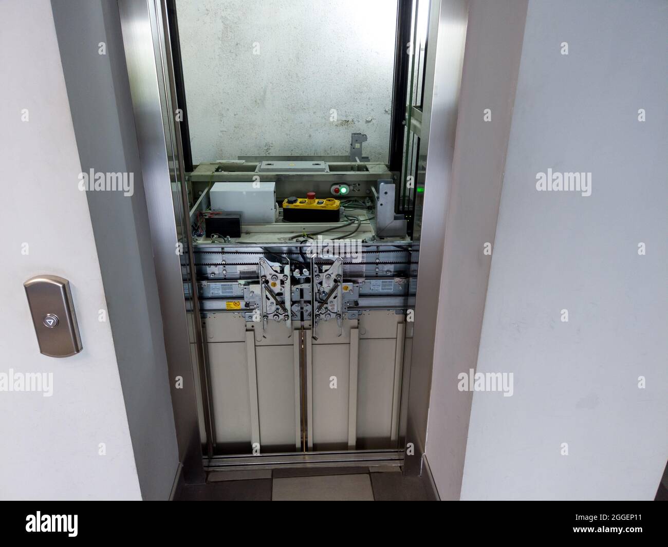 Aufzug wird gewartet. Beschädigtes Hubgerüstwerk im offenen Hubgerüstschaft. Außer Betrieb gefahrter Stahlaufzug. Stockfoto