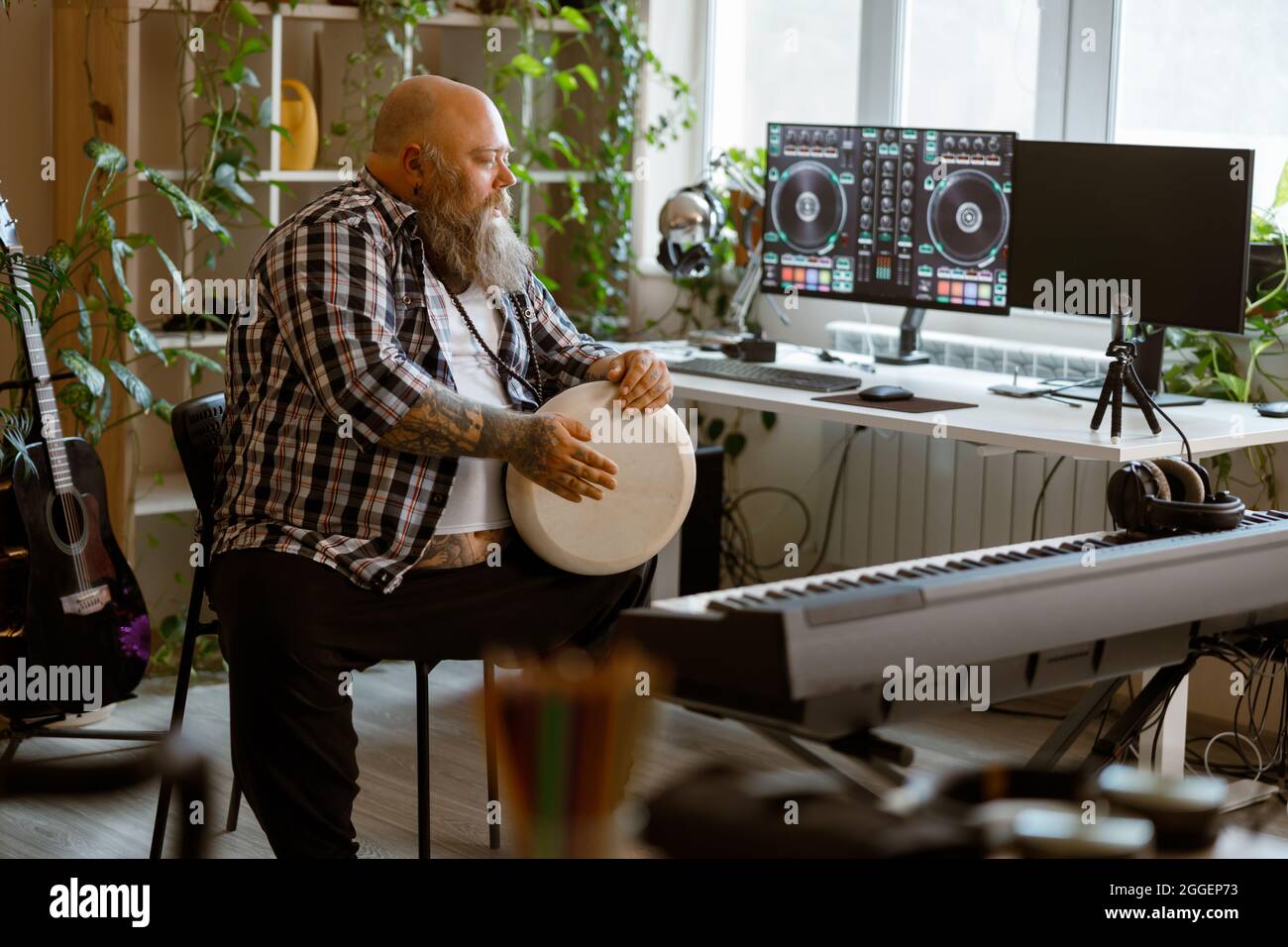 Positine übergewichtiger Mann spielt Trommel sitzt im Hause Audio-Studio Stockfoto