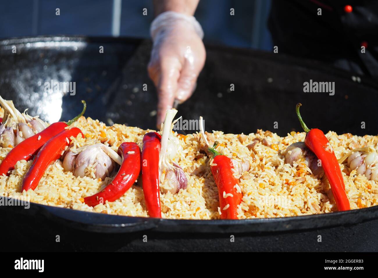 Kochen Pilaf in einem großen Bottich auf dem Grill. Usbekischer Pilaf. Hochwertige Fotos Stockfoto