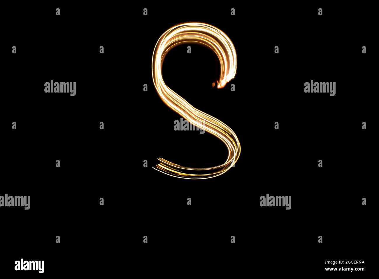 Buchstabe S. Licht Malerei Alphabet. Langzeitbelichtung. Gezeichneter Buchstabe S mit goldenen Lichtern auf schwarzem Hintergrund. Stockfoto