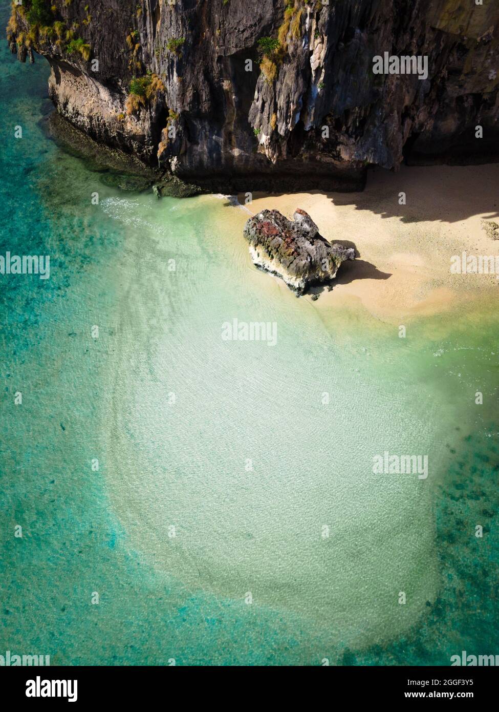 Luftdrohne schoss direkt auf einen Strand von Railay, Thailand, mit klarem Wasser und Felsen in der Nähe. Stockfoto