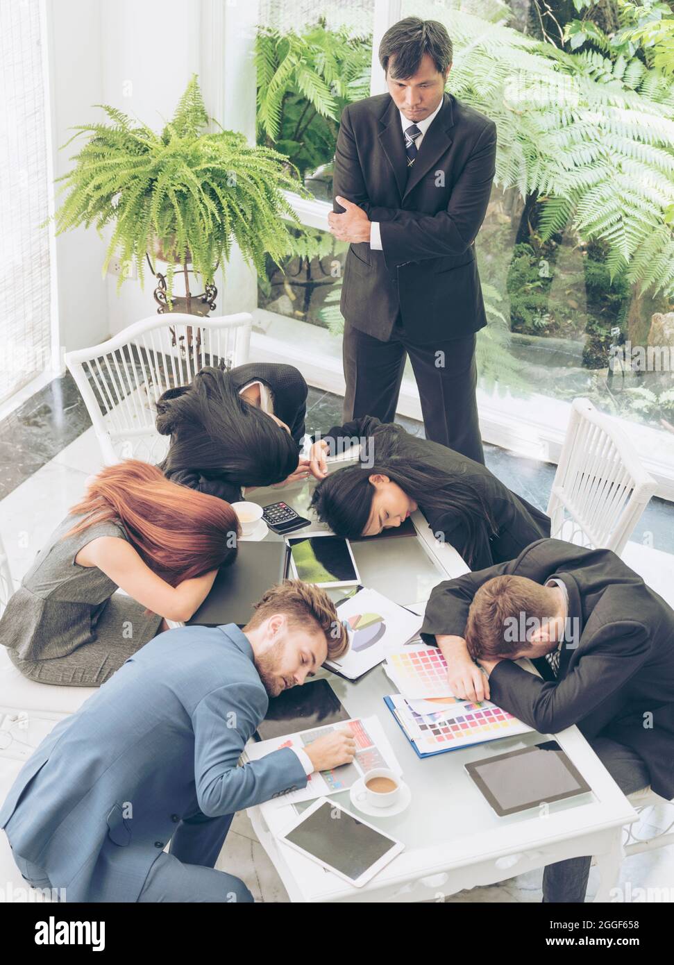 Der faule Arbeiter schläft erschöpft von einem müden Treffen. Eine Gruppe von Geschäftsleuten, die nach dem Meeting im Konferenzraum schlafen. Geschäftsführer und Stockfoto