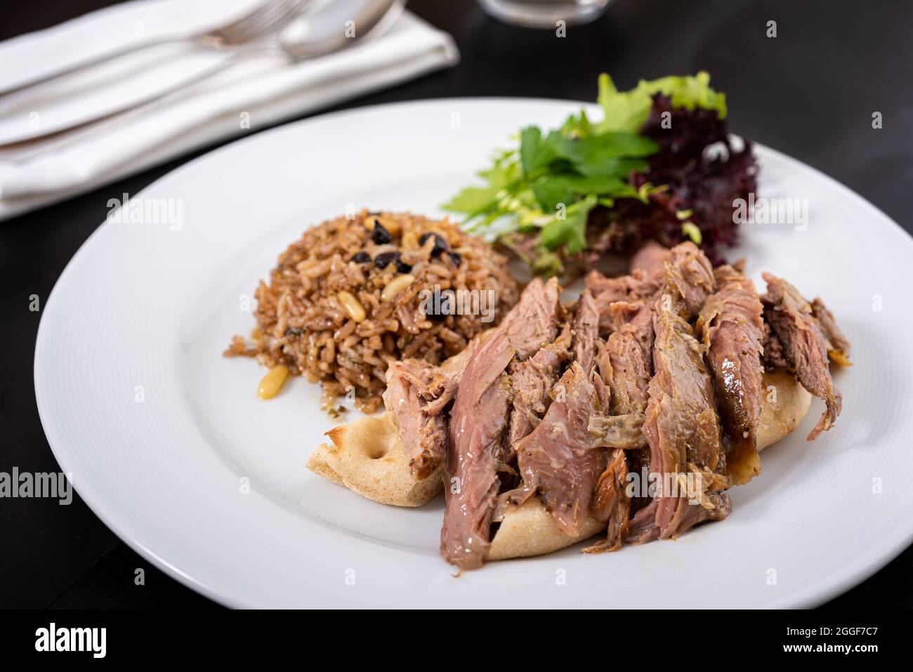 Die Tandoori-Lammkrone auf der Pita ist Tandoori. Kuzu Tandir Kebap. Pistazien und Johannisbeerreis. Stockfoto
