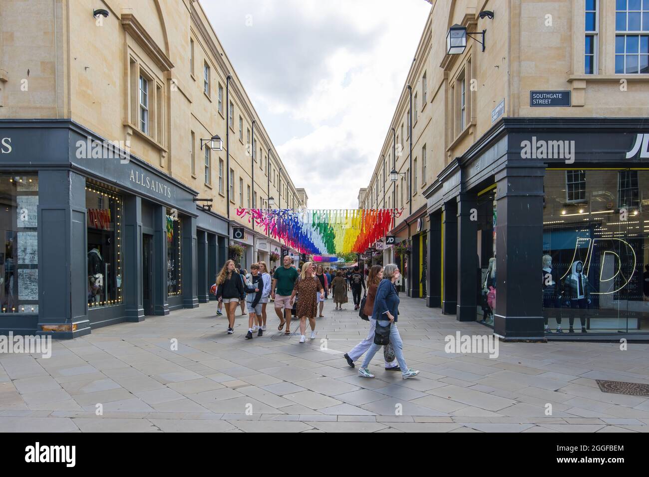 Shopper Walking under the vibring rainbow aunting Installation in St Lawrence Street, Southgate, Bath, UK on the 24. August 2021 Stockfoto