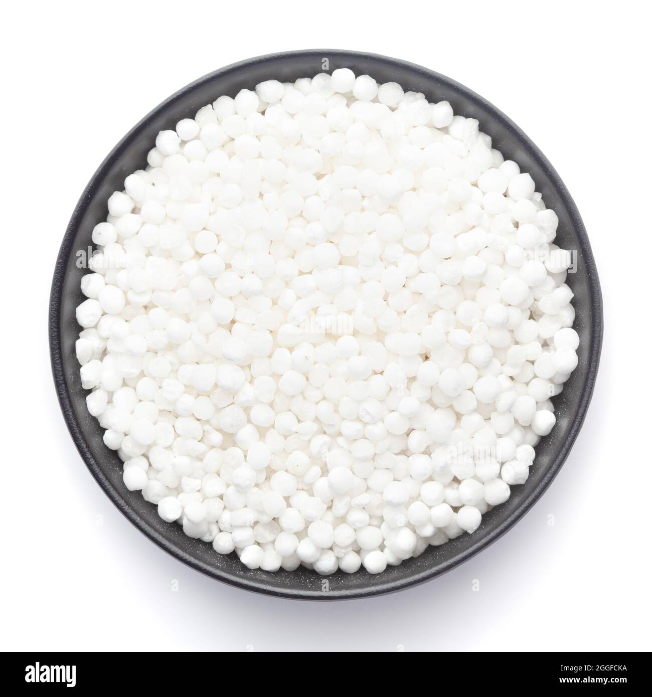 Makro Nahaufnahme von organischem weißem Sago oder Sabudana in großer Größe auf einer schwarzen Keramikschale, Draufsicht Stockfoto