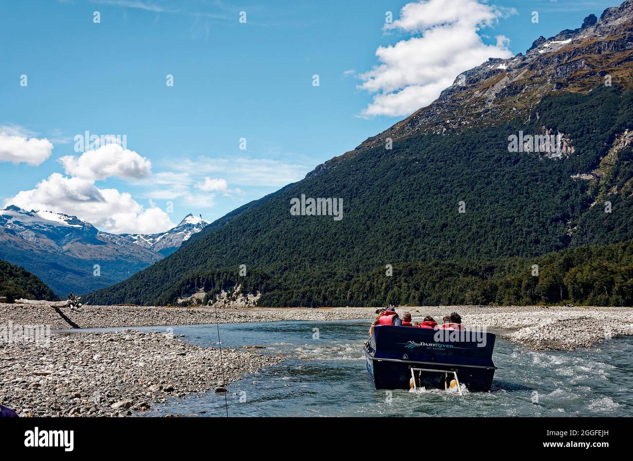 Jet-Boot bewegt, Passagiere, tragen rote Schwimmwesten, spannende Fahrt, seichtes Wasser, Felsenflußbett, Berge, Ausflug, Dart River, Paradies, New Z Stockfoto