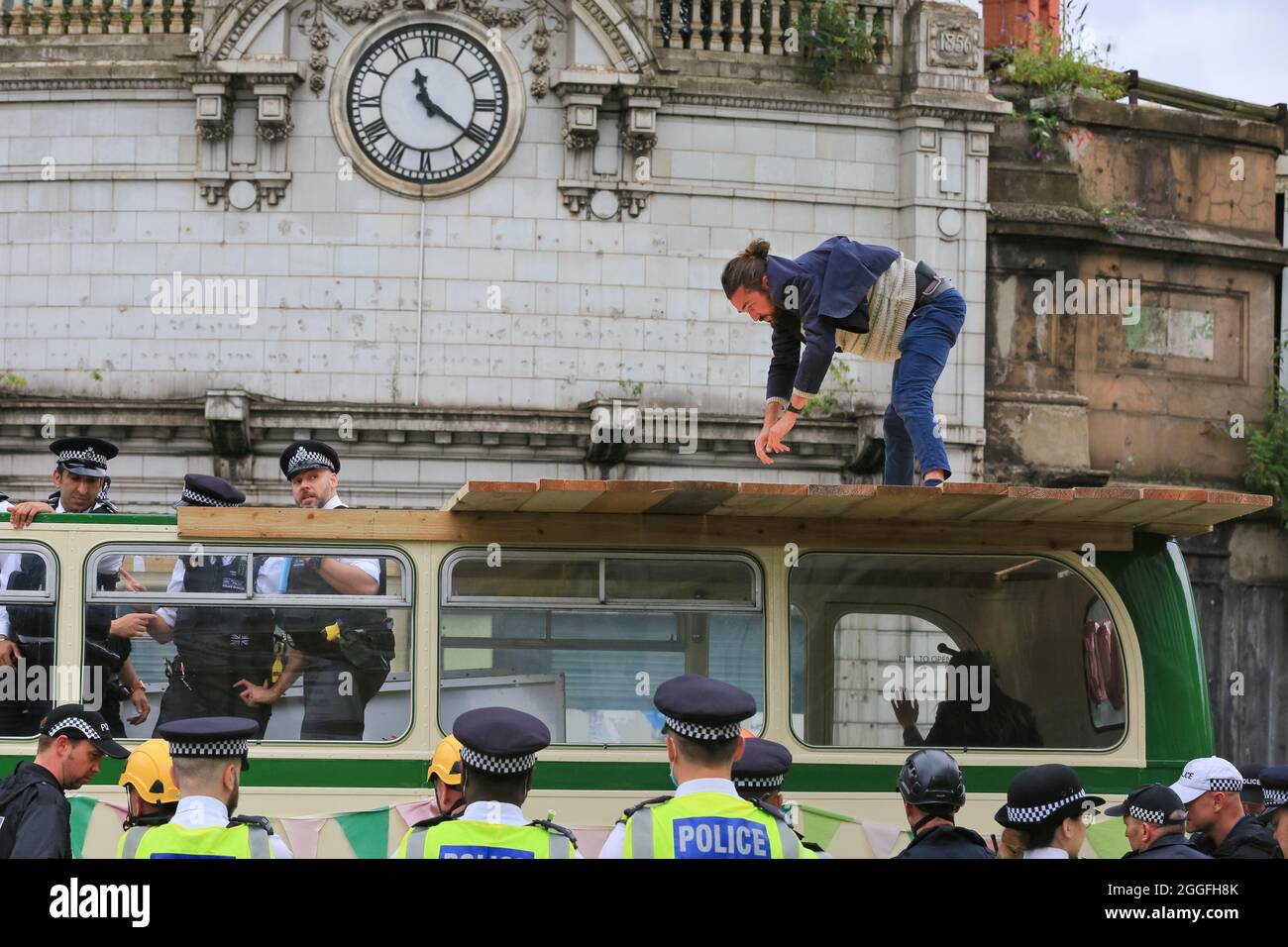 City of London, Großbritannien. August 2021. Demonstranten werden verhaftet und vom Tatort weggeführt. Extinction Rebellion (XR) hat die London Bridge mit einem Oldtimer-Bus blockiert, mehrere Demonstranten wurden geklebt und auf andere Weise an Bus und Boden befestigt und mussten von der Polizei entfernt werden. Kredit: Imageplotter/Alamy Live Nachrichten Stockfoto