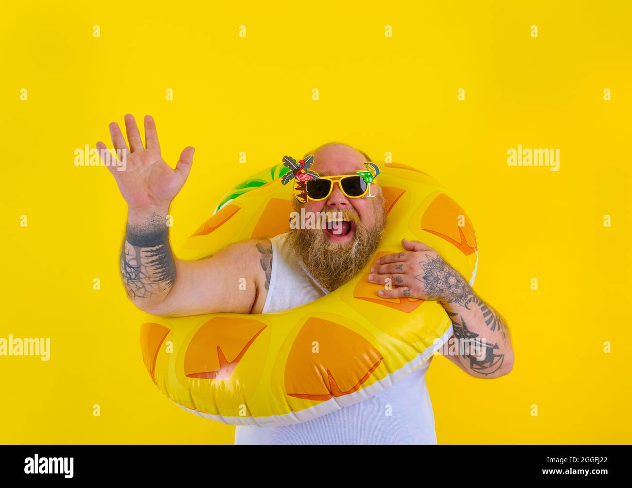 Fat glücklicher Mann mit Perücke im Kopf ist bereit, mit einem Donut  Lebensretter schwimmen Stockfotografie - Alamy