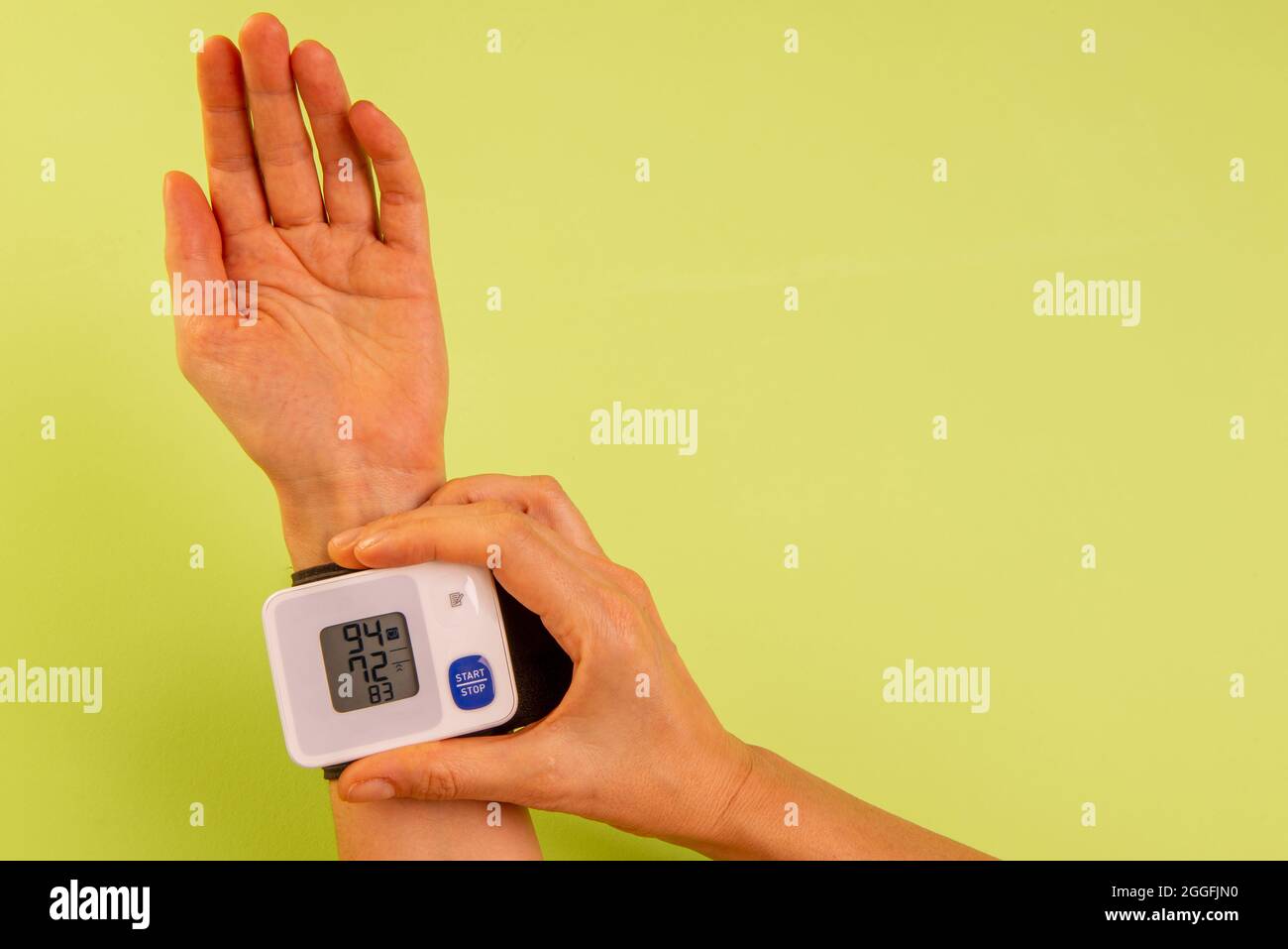 Die Hand der Frau misst ihren Blutdruck. Stockfoto