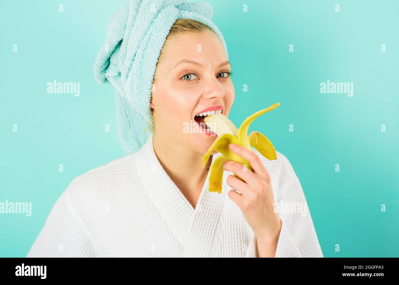 Lächelnde Frau essen Banane. Glückliches Mädchen auf Diät beim Frühstück. Gesunder Lebensstil. Stockfoto