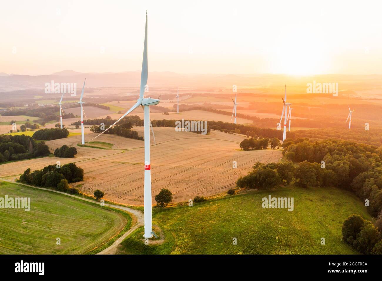Luftaufnahme von Windenergieanlagen und Windmühlen im Feld. Alternative grüne elektrische Energieerzeugung. Stockfoto