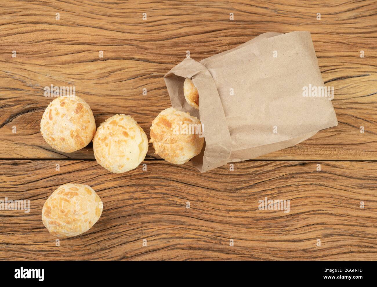 Typische brasilianische Käsebrühen in einem Papierbeutel über einem Holztisch. Stockfoto