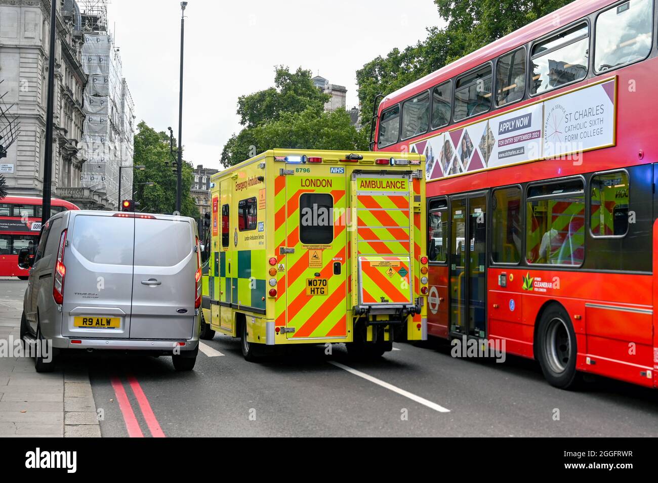 London, England - 2021. August: Londoner Krankenwagen mit blauen Lichtern, die zwischen dem Londoner Verkehr als Reaktion auf einen Notruf quietschten Stockfoto