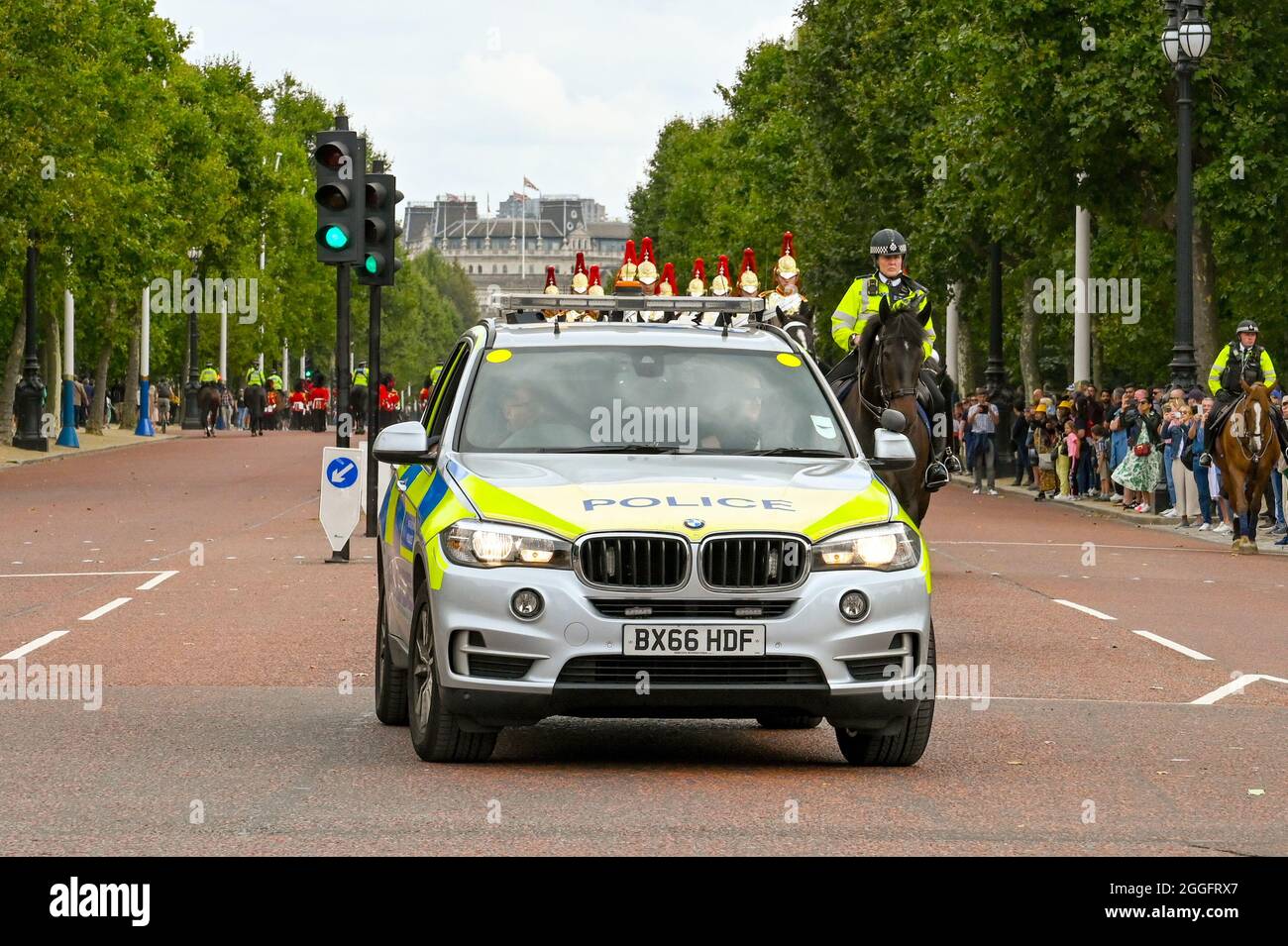 London, England - 2021. August: Polizei patrouilliert Auto eskortiert Soldaten auf dem Pferderücken die Mall hinunter. Stockfoto