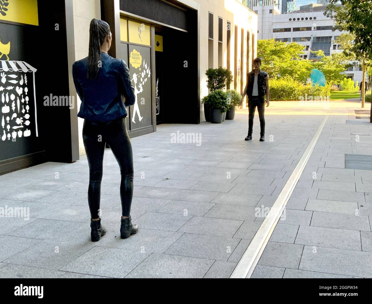 Hohe Statuen von Mann und Frau in Canary Wharf, London, Großbritannien Stockfoto