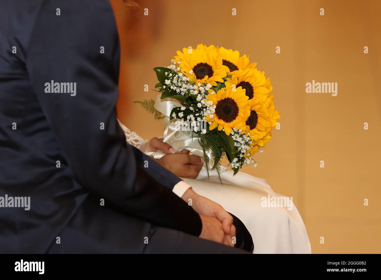 Brautpaar in der Kirche mit einem Blumenstrauß während der Zeremonie in der Kirche Stockfoto