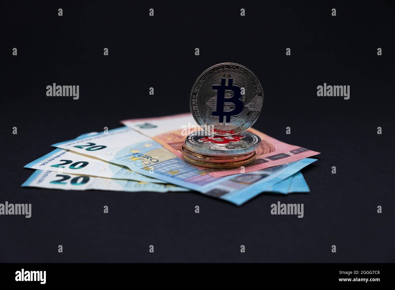 Bitcoins auf 20 und 10 Euro Banknoten. Bitcoins auf zehn- und zwanzig-Euro-Banknoten auf dunklem Hintergrund. Stockfoto