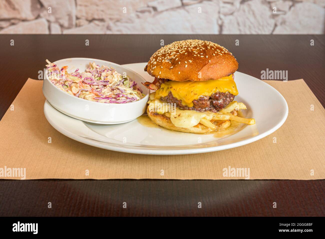 Rindfleisch-Burger mit zwei Arten von geschmolzenem Käse, pommes im Inneren des Burgers und American Coleslaw Stockfoto