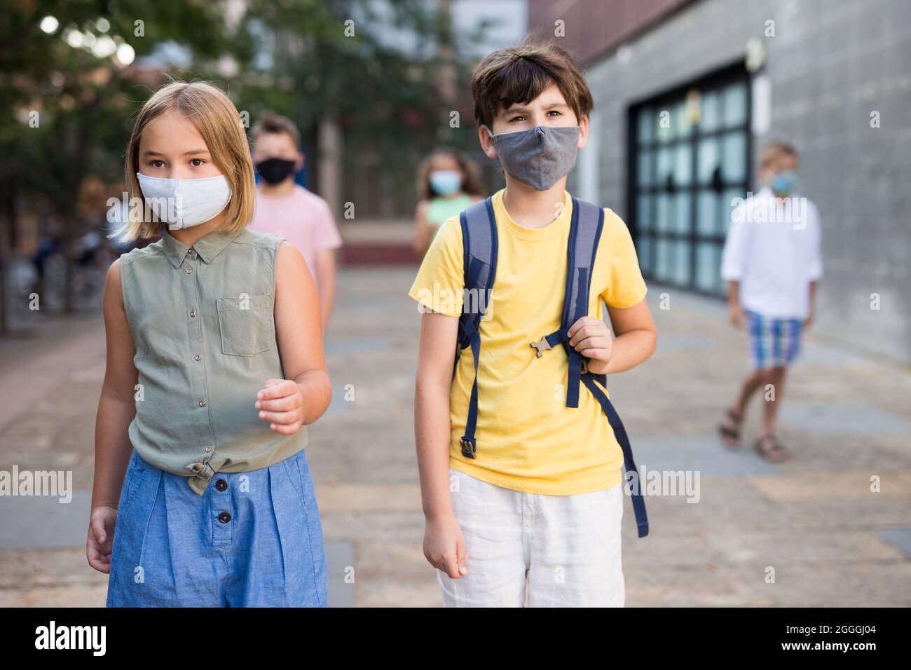 Junge Mädchen und Jungen in Masken zusammen gehen Stockfoto