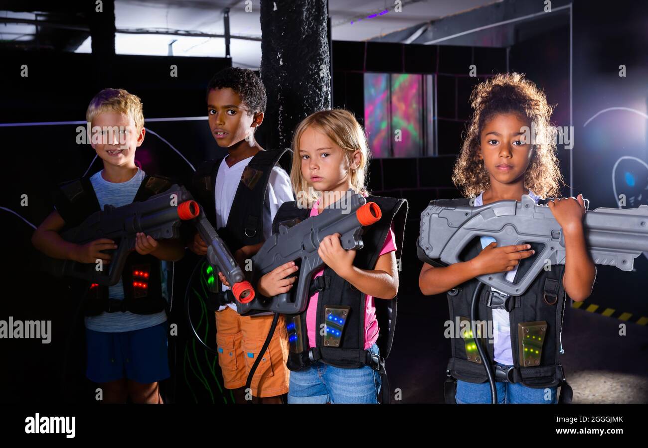 Group Portrait von positiven lächelnden Teenager mit Laserwaffen Spaß auf dunklen lasertag Arena Stockfoto