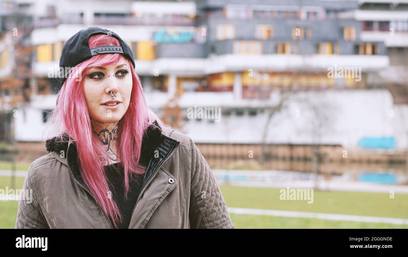 Frau mit rosafarbenem Haar auf dem Sozialwohnsitz Stockfoto