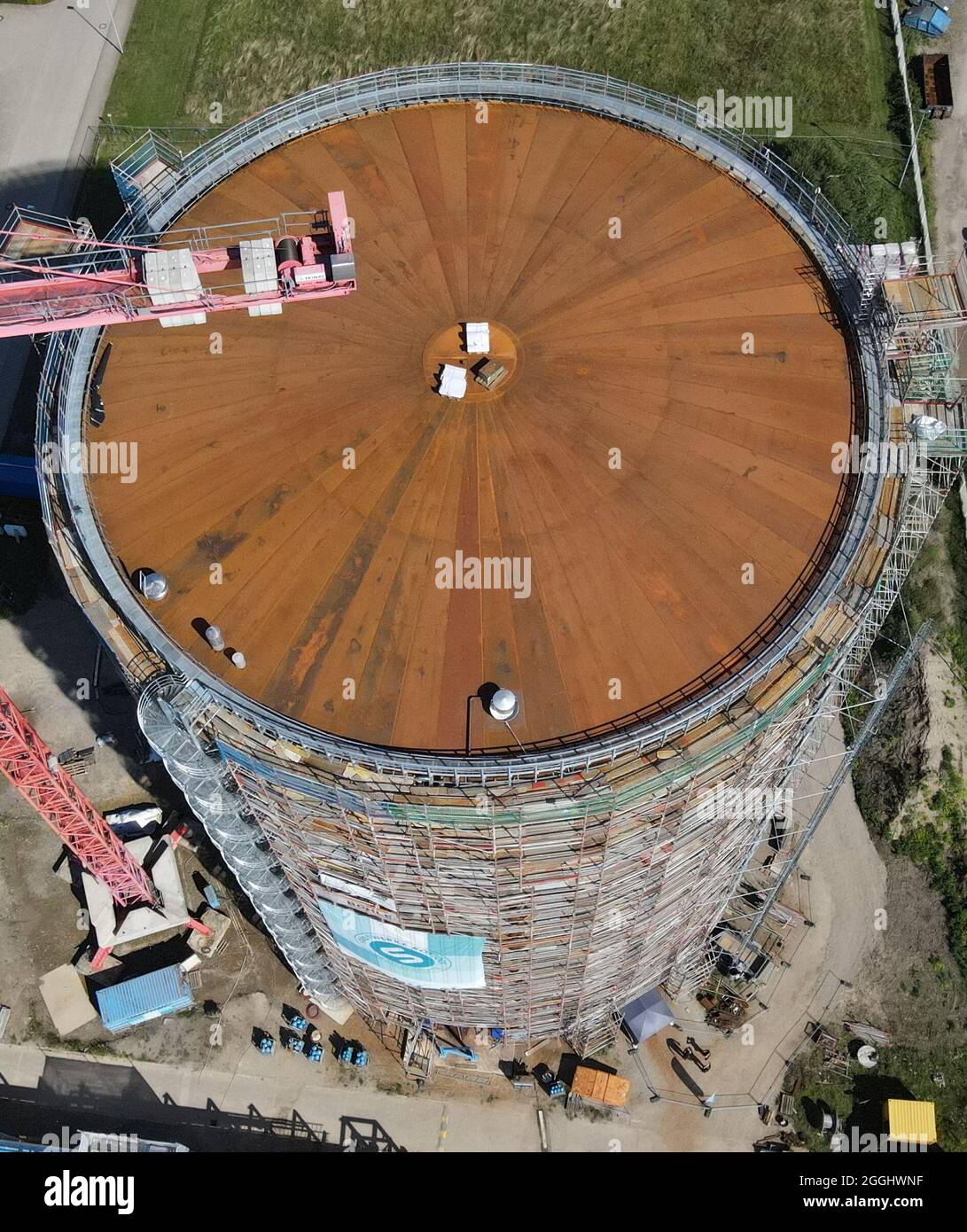 Rostock, Deutschland. September 2021. Das Richtfest für den neuen Wärmespeicher der Stadtwerke Rostock findet statt. Der Grundstein für das 55 Meter hohe Bauwerk am Warnow River wurde vor eineinhalb Jahren gelegt, die Inbetriebnahme ist für das Frühjahr 2022 geplant. Der drucklose Stahltank speichert 45 Millionen Liter Wasser bei einer Temperatur von 98 Grad Celsius und führt es bei Bedarf in das Heiznetz ein. Das Reservoir wird unter anderem dazu beitragen, Energie aus Windturbinen und Solarmodulen zu speichern. (Luftaufnahme mit Drohne/Kopter) Credit: Be/dpa/Alamy Live News Stockfoto