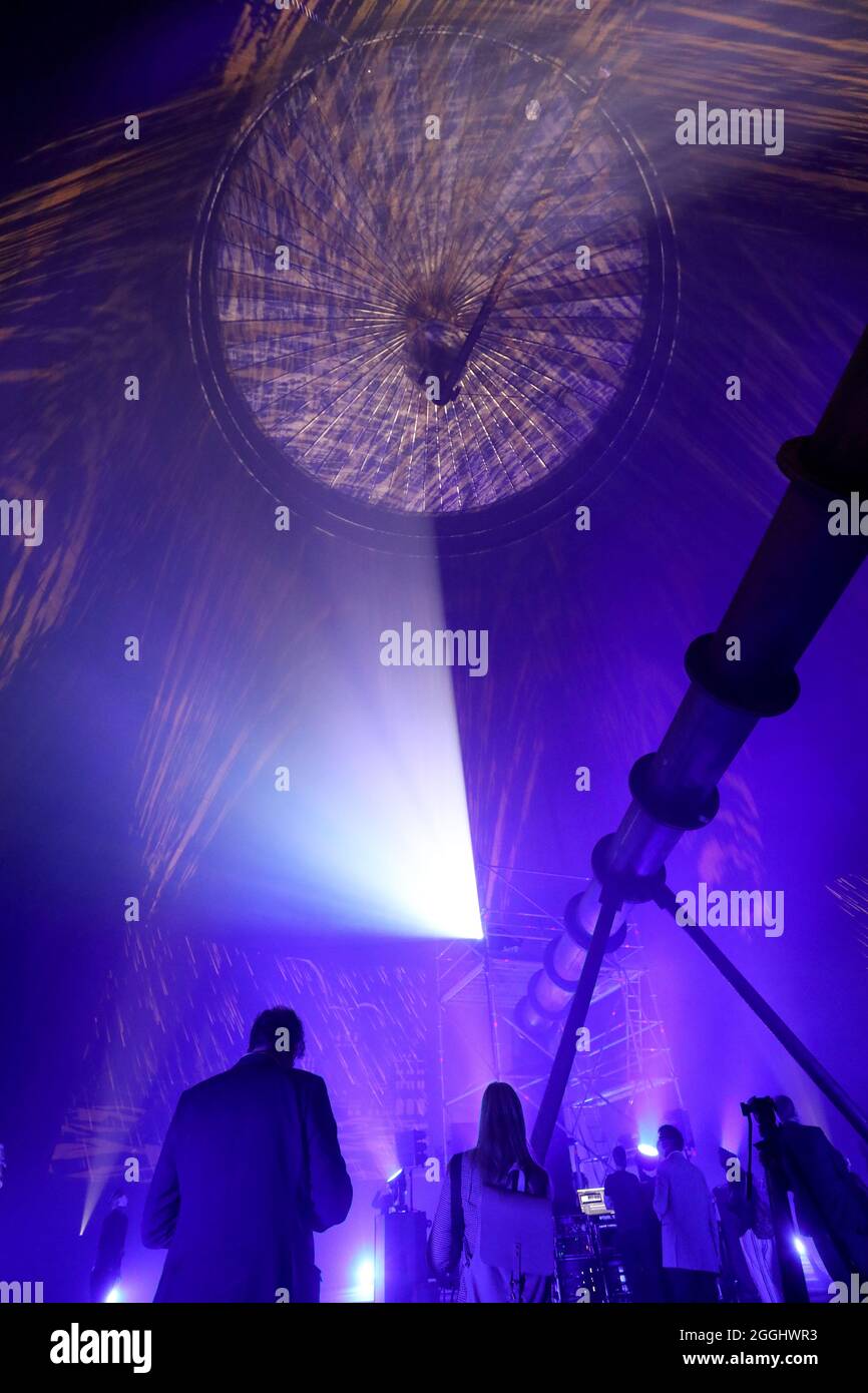 01. September 2021, Mecklenburg-Vorpommern, Rostock: Das Richtfest des neuen Wärmespeichers der Stadtwerke Rostock wird mit einer Laser- und Lichtshow im Inneren gefeiert. Der Grundstein für das 55 Meter hohe Bauwerk am Warnow River wurde vor eineinhalb Jahren gelegt, die Inbetriebnahme ist für das Frühjahr 2022 geplant. Der drucklose Stahltank speichert 45 Millionen Liter Wasser bei einer Temperatur von 98 Grad Celsius und führt es bei Bedarf in das Heiznetz ein. Der Speicher soll unter anderem dazu beitragen, Energie aus Windenergie und Solar pla zu speichern Stockfoto