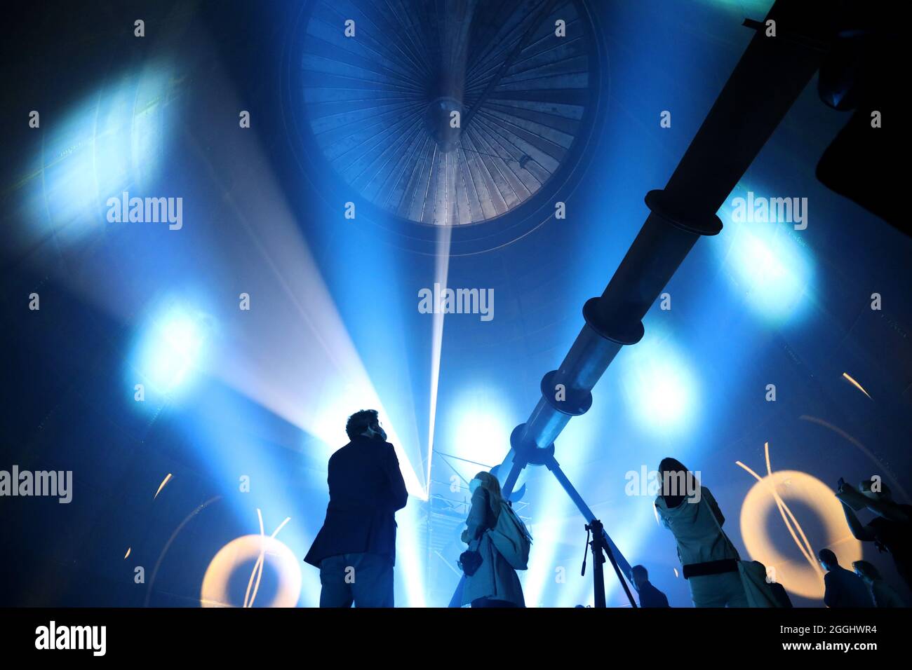 01. September 2021, Mecklenburg-Vorpommern, Rostock: Das Richtfest des neuen Wärmespeichers der Stadtwerke Rostock wird mit einer Laser- und Lichtshow im Inneren gefeiert. Der Grundstein für das 55 Meter hohe Bauwerk am Warnow River wurde vor eineinhalb Jahren gelegt, die Inbetriebnahme ist für das Frühjahr 2022 geplant. Der drucklose Stahltank speichert 45 Millionen Liter Wasser bei einer Temperatur von 98 Grad Celsius und führt es bei Bedarf in das Heiznetz ein. Der Speicher soll unter anderem dazu beitragen, Energie aus Windenergie und Solar pla zu speichern Stockfoto