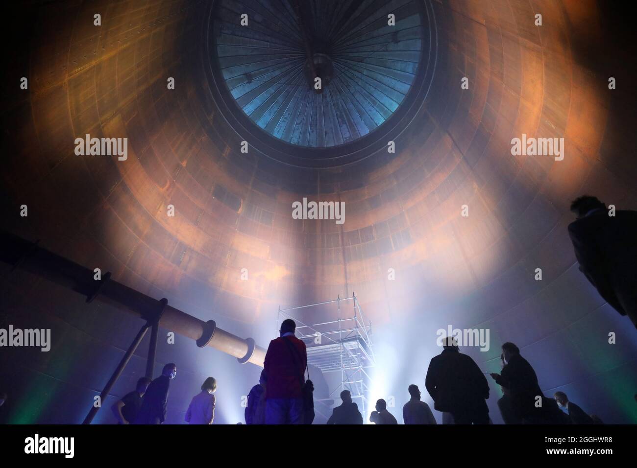 01. September 2021, Mecklenburg-Vorpommern, Rostock: Das Richtfest des neuen Wärmespeichers der Stadtwerke Rostock wird mit einer Laser- und Lichtshow im Inneren gefeiert. Der Grundstein für das 55 Meter hohe Bauwerk am Warnow River wurde vor eineinhalb Jahren gelegt, die Inbetriebnahme ist für das Frühjahr 2022 geplant. Der drucklose Stahltank speichert 45 Millionen Liter Wasser bei einer Temperatur von 98 Grad Celsius und führt es bei Bedarf in das Heiznetz ein. Der Speicher soll unter anderem dazu beitragen, Energie aus Windenergie und Solar pla zu speichern Stockfoto