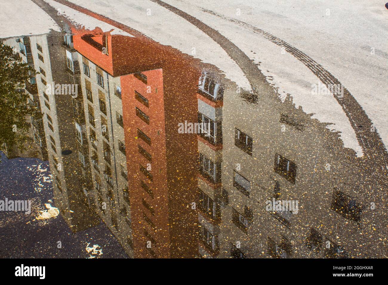 Spiegelung eines Wohnblocks in einem Teich, nach heftigem Regen in Bukarest, Rumänien. Stockfoto