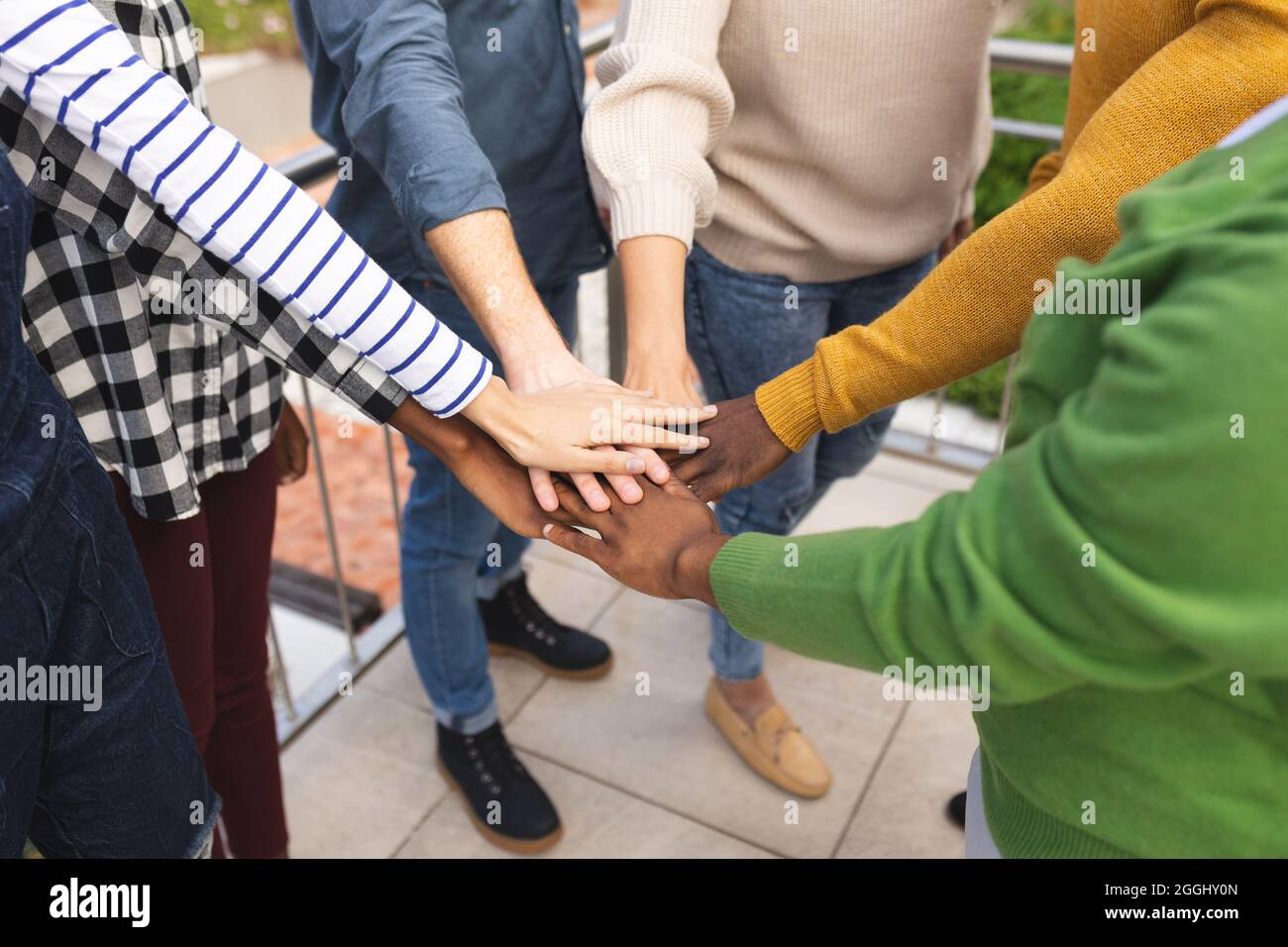 Diverse männliche und weibliche Kollegen bei der Arbeit, die sich zusammenschließen Stockfoto