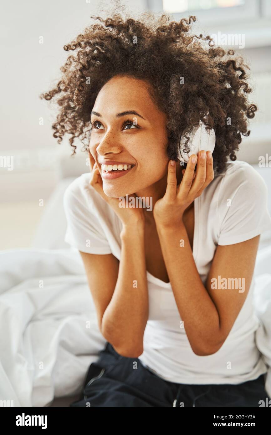 Temperamentvolle Frau mit kabellosen Kopfhörern, die ihren Lieblingslied hört Stockfoto