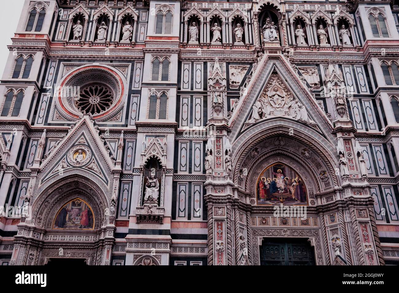 Fassade des Florentiner Duomo aus polychromem Marmor mit Nischen, Mosaiken und Rosenfenstern, Italien. Stockfoto