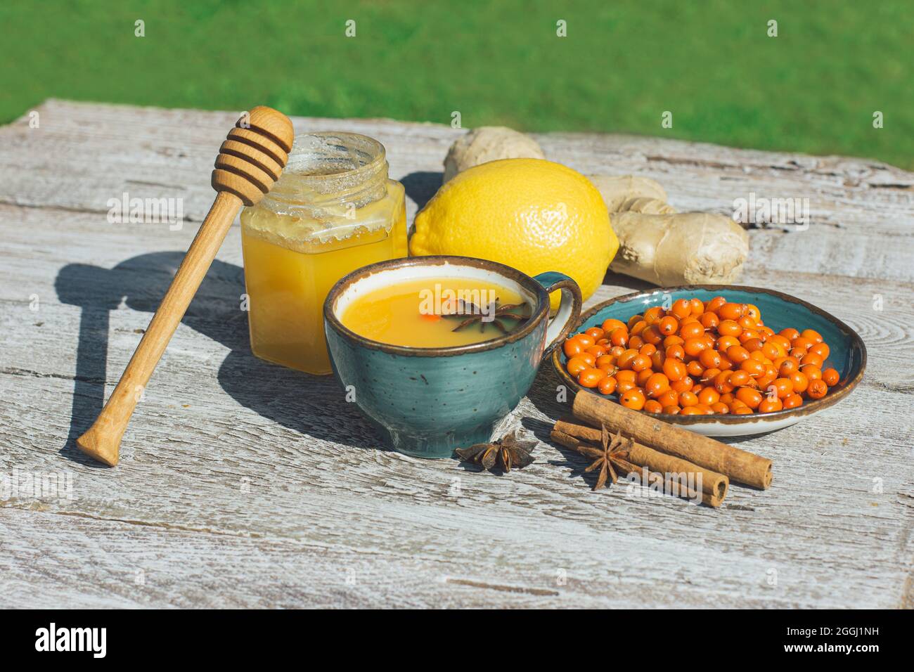 Sanddorntee, Honig, Zitrone und Ingwer auf einem Holztisch. Anti-Kälte-Tee ist ein Antioxidans für die Gesundheit in der Grippesaison Stockfoto