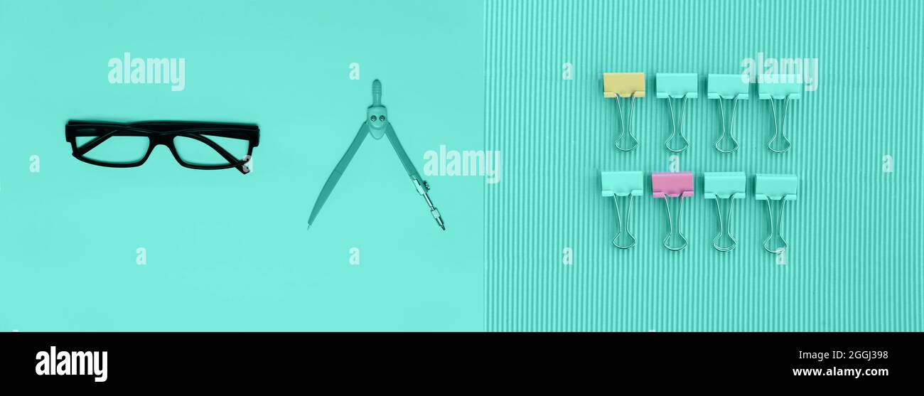 Schwarze Brillen und pastellfarbene bunte Kompasse und Clip für Schule oder Bildung oder Wirtschaft mintgrüner Hintergrund Stockfoto