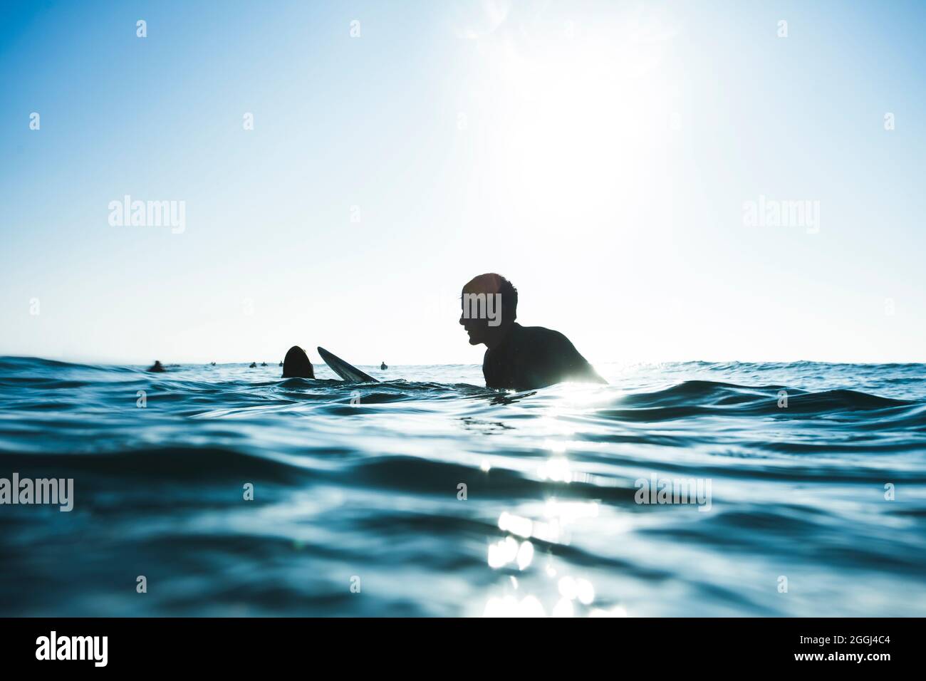 Surfer wartet auf Welle, sitzt an Bord, blau Stockfoto